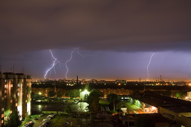 Un forte fulmine sopra un cielo grigio scuro colpisce il suolo illuminando la città