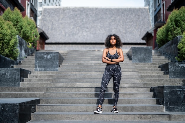 Un forte velocista femminile atletico Donne africane in piedi in città che indossano nel concetto di motivazione di fitness e sport di abbigliamento sportivo con spazio di copia Donne nere sorridenti allegre che guardano la macchina fotografica