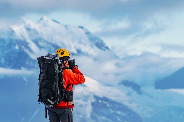 Un fotografo alpinista dilettante con un grande zaino