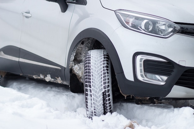 Un frammento della parte anteriore di un SUV con fari fendinebbia paraurti anteriore su una strada invernale