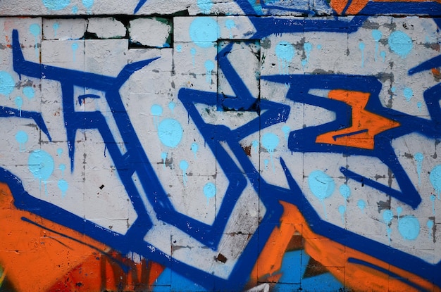 Un frammento di disegno di graffiti che utilizza contorni applicati al muro con l'aiuto di bombolette con vernici aerosol sulle aree di riempimento colorate Texture di sfondo di street art e vandalismo