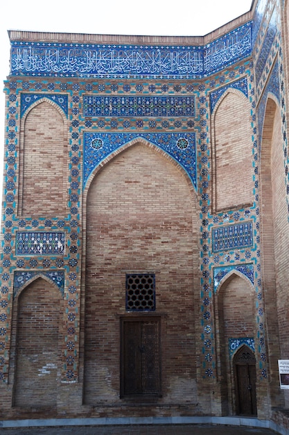 Un frammento di parete decorata con mosaici e ornamenti con antiche porte in legno nel mausoleo di Gur Emir a Samarcanda, Uzbekistan. 29.04.2019