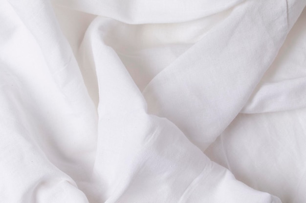 Un frammento di tessuto bianco stropicciato come trama di sfondo. Tessuto di lino o cotone bianco stropicciato.