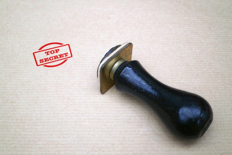 Foto un francobollo di gomma su una carta marrone con un francobollo rosso top secret accanto