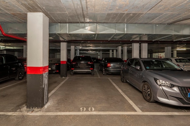 Un garage buio con auto parcheggiate e posti liberi