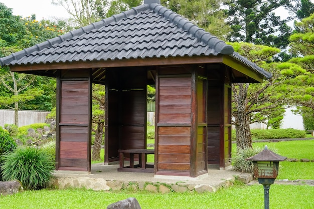 Un gazebo in legno con una panca al centro.