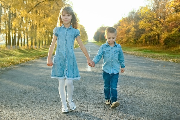 Un genitore felice con il bambino sta camminando lungo la strada nel parco durante il viaggio nella natura