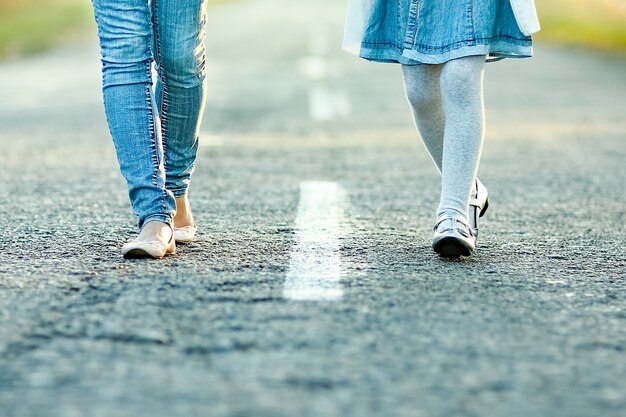 Un genitore felice con il bambino sta camminando lungo la strada nel parco durante il viaggio nella natura