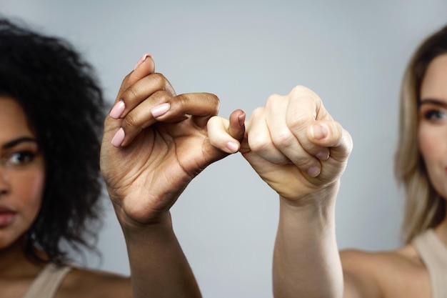 Un gesto di promessa mignolo tra donne africane e caucasiche Cura e sostegno dell'amicizia interrazziale