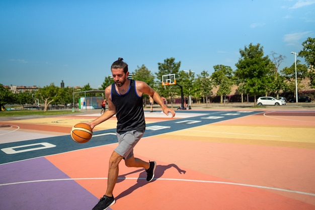 Un giocatore di basket maschile corre su un campo da basket con una palla