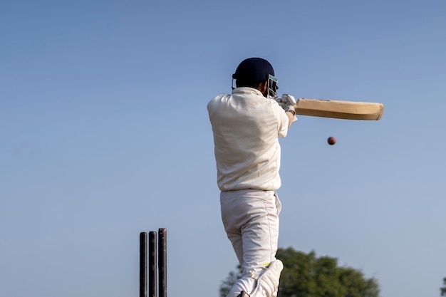 Un giocatore di cricket che gioca a cricket sul campo in abito bianco per una partita di test un atleta che colpisce un colpo