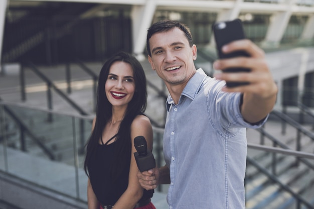 Un giornalista fa un selfie con una ragazza.