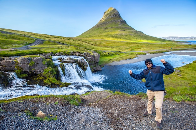 Un giovane a Kirkjufellsfoss in una mattina d'estate alle cascate. Islanda