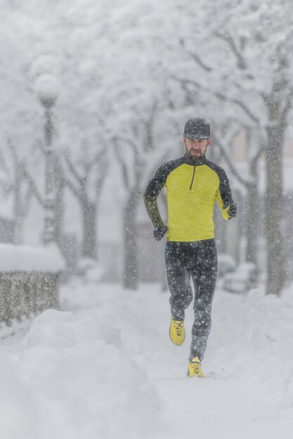 Un giovane atleta con la barba durante una corsa sulla neve