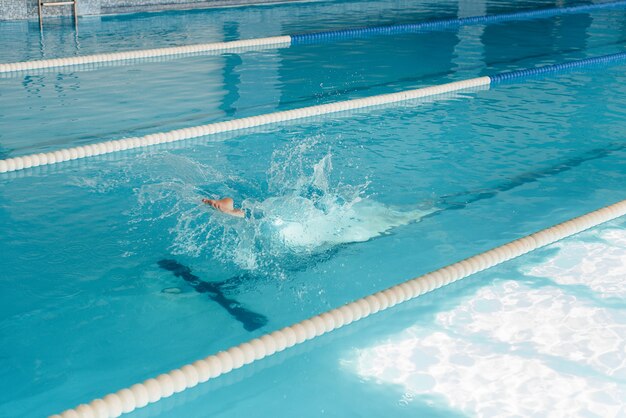 Un giovane atleta si allena e si prepara per le gare di nuoto in piscina. Uno stile di vita sano.