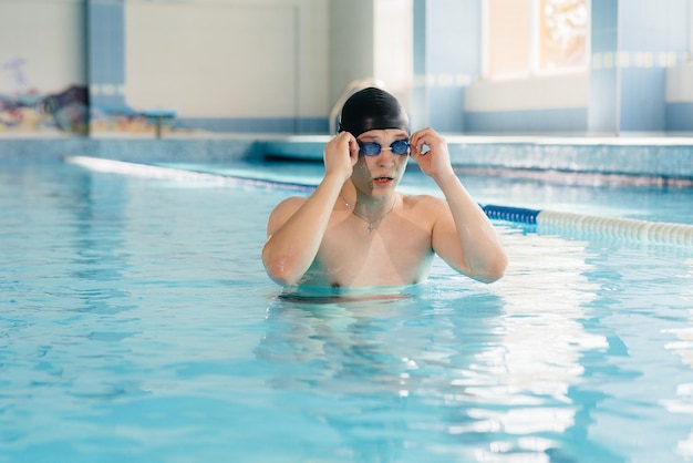 Un giovane atleta si allena e si prepara per le gare di nuoto in piscina. Uno stile di vita sano.
