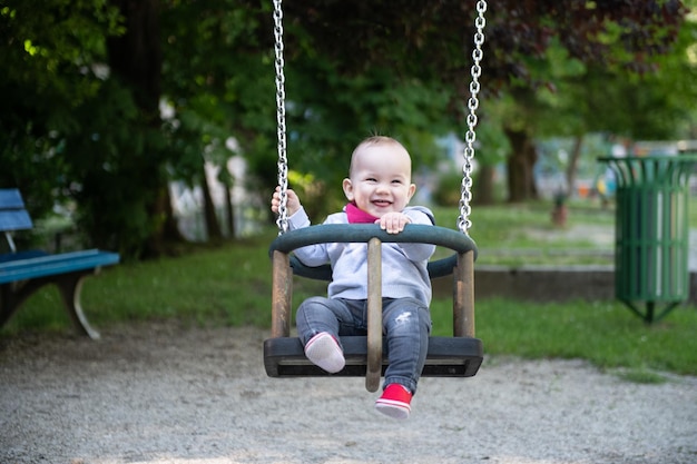 Un giovane bambino che oscilla in un parco