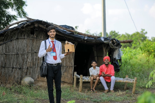 Un giovane banchiere o agronomo indiano visita una povera famiglia di contadini