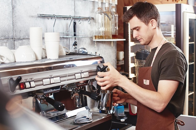 Un giovane barista lavora al bar.