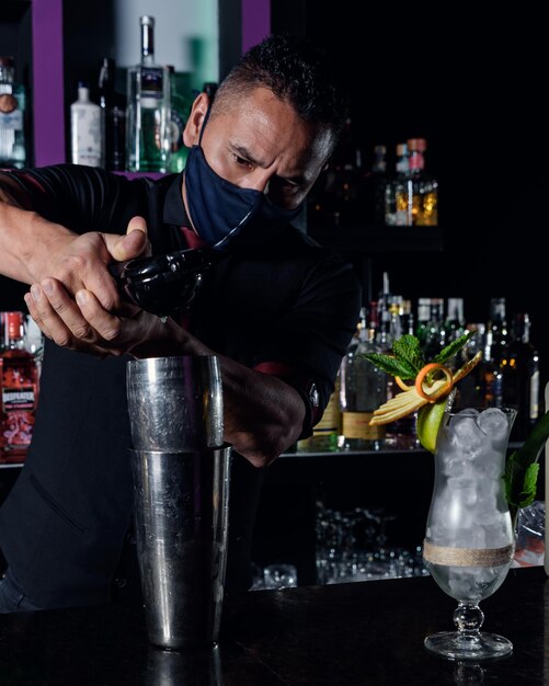 Un giovane barista professionista prepara cocktail per i suoi clienti al concetto di professione lavorativa