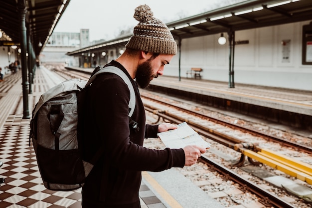 Un giovane che aspetta alla stazione dei treni