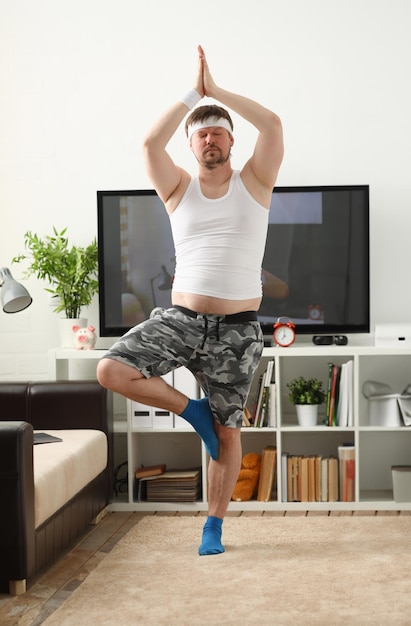 Un giovane che pratica yoga e pilates a casa sogna di ripristinare un'eccellente figura dopo un carico intenso per il corpo per perdere peso