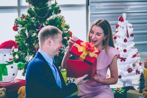 Un giovane dà il regalo a una giovane donna.