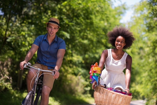 un giovane e una bella ragazza afroamericana che si godono un giro in bicicletta nella natura in una soleggiata giornata estiva