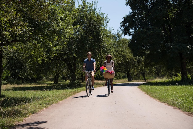 un giovane e una bella ragazza afroamericana che si godono un giro in bicicletta nella natura in una soleggiata giornata estiva