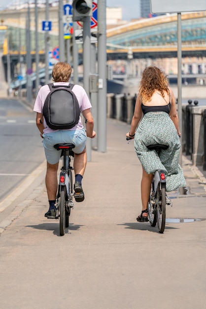 Un giovane e una ragazza stanno andando in bicicletta Ciclisti sulla strada della città