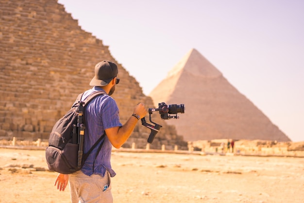 Un giovane fotografo presso la piramide di Cheope, la piramide più grande