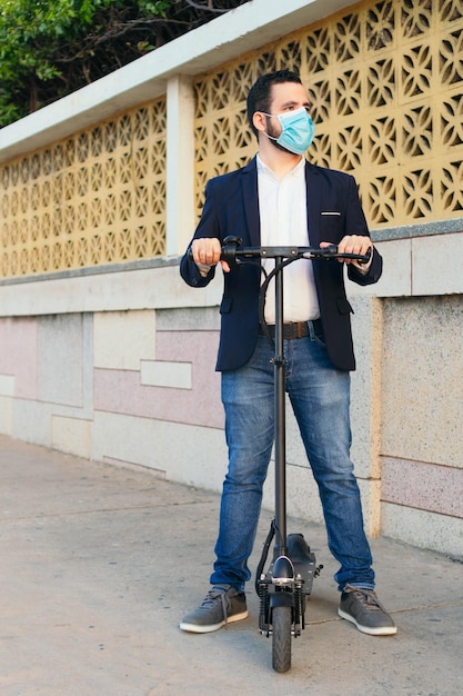 Un giovane in maschera guida uno scooter in città durante la pandemia