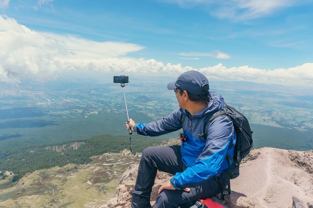Un giovane in montagna che si fa selfie