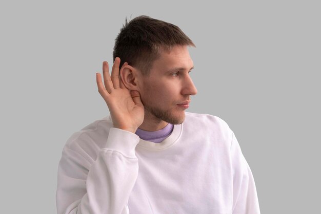 Un giovane maschio che tiene la sua mano sopra il concetto di problemi di udito dell'orecchio