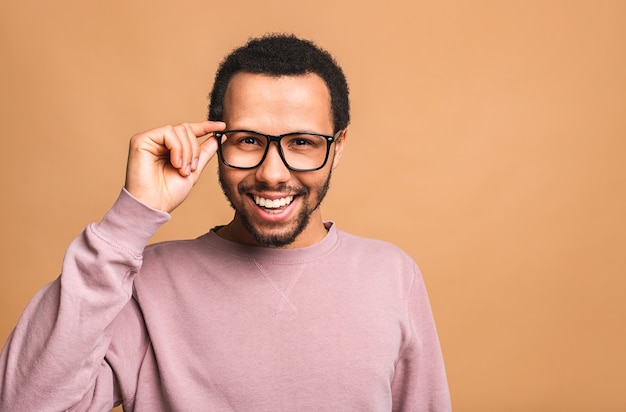 Un giovane maschio divertente sorridente felice isolato contro il beige.