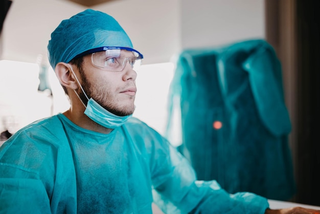 un giovane medico chirurgo in uniforme lavora in un ospedale davanti allo schermo