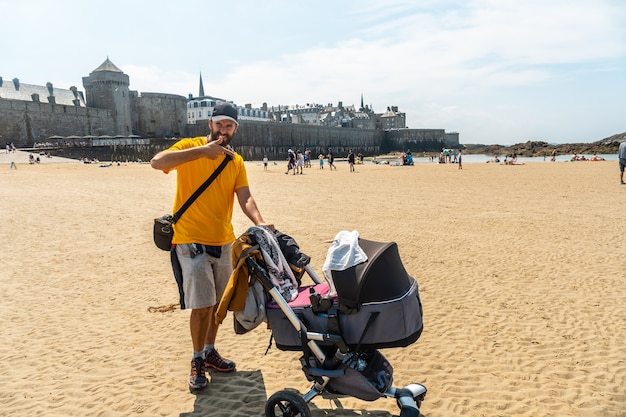 Un giovane padre che si gode l'estate sulla Grande Plage du Sillon de Saint-Malo nella Bretagna francese, France