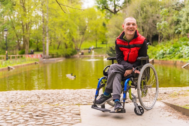 Un giovane paralizzato in un parco pubblico della città seduto sulla sedia a rotelle