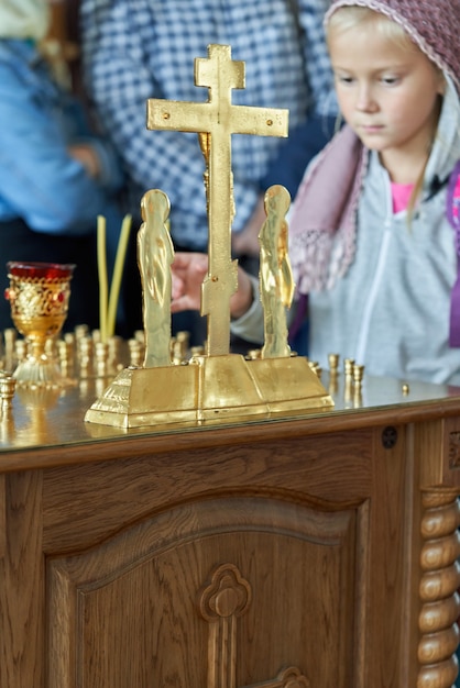 Un giovane parrocchiano accende una candela all'altare della chiesa. Ragazza credente con le candele in chiesa