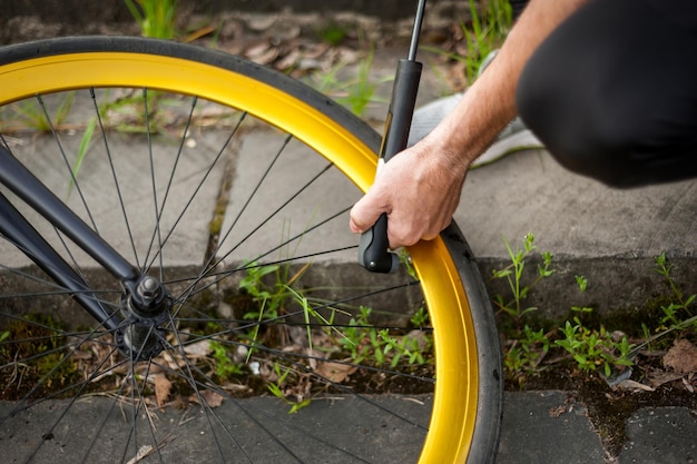 Un giovane pompa la ruota della sua bicicletta Lo fa usando una pompa a mano per pompare aria