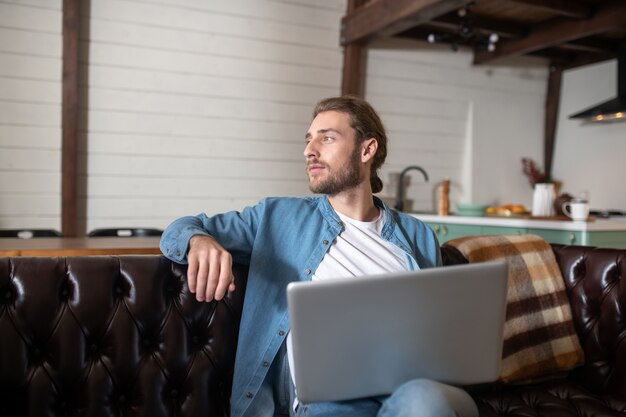 Un giovane premuroso che lavora con il suo laptop