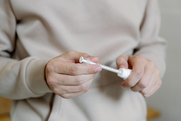 Un giovane prepara la medicina con una siringa