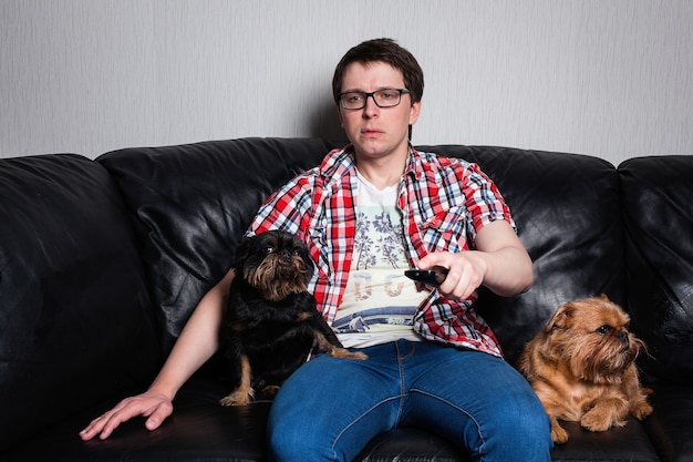 Un giovane ragazzo che guarda la TV a casa con i cani.