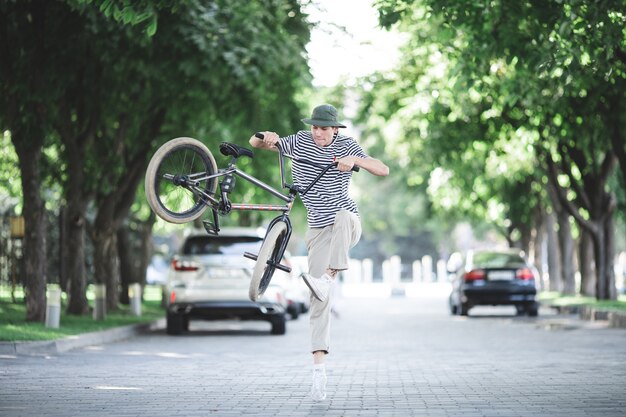 Un giovane ragazzo che salta su una bmx per strada