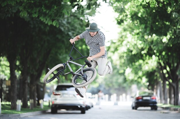 Un giovane ragazzo che salta su una bmx per strada