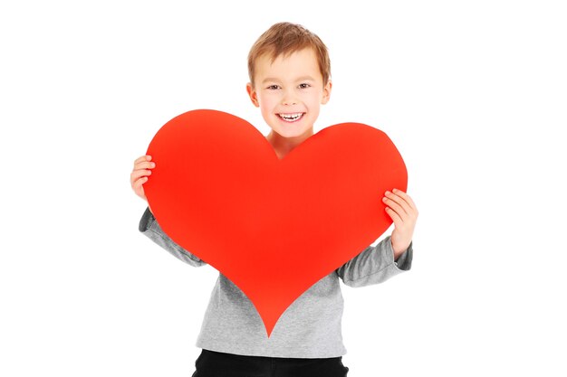 un giovane ragazzo che tiene un cuore su sfondo bianco