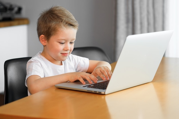 Un giovane ragazzo che utilizza un computer portatile