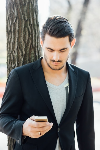 Un giovane ragazzo italiano utilizzando uno smartphone