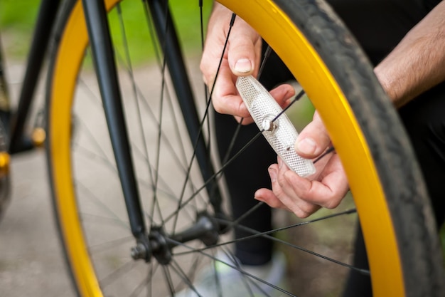 Un giovane ripara la ruota della sua bicicletta