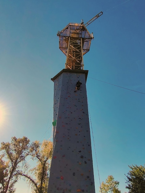 Un giovane si arrampica sul muro per arrampicarsi con attrezzature speciali Vista dal basso